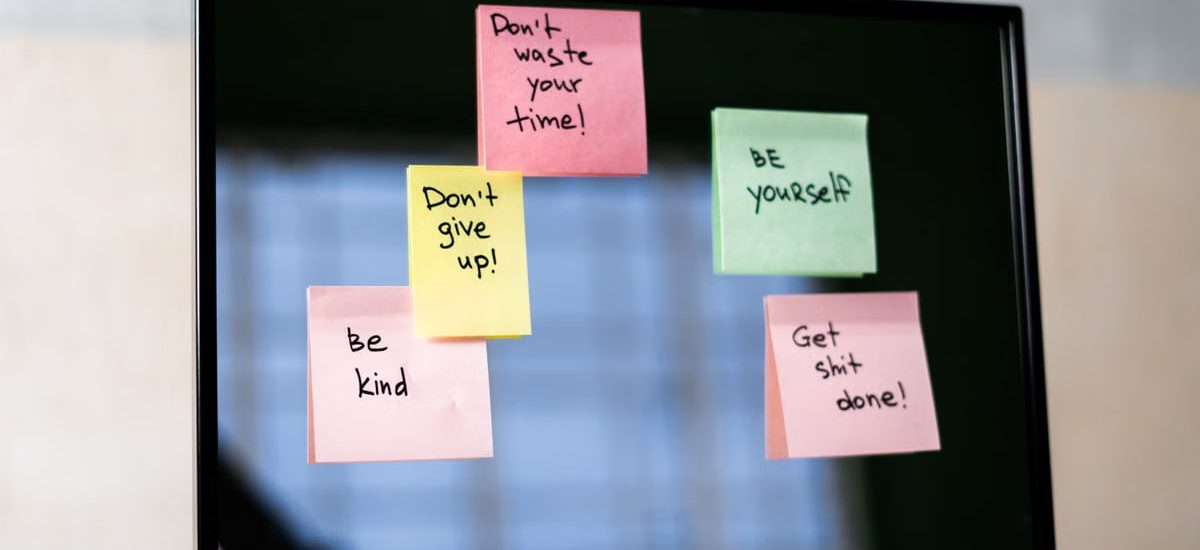 Colorful sticky notes on a mirror provide daily motivational messages and positivity reminders.
